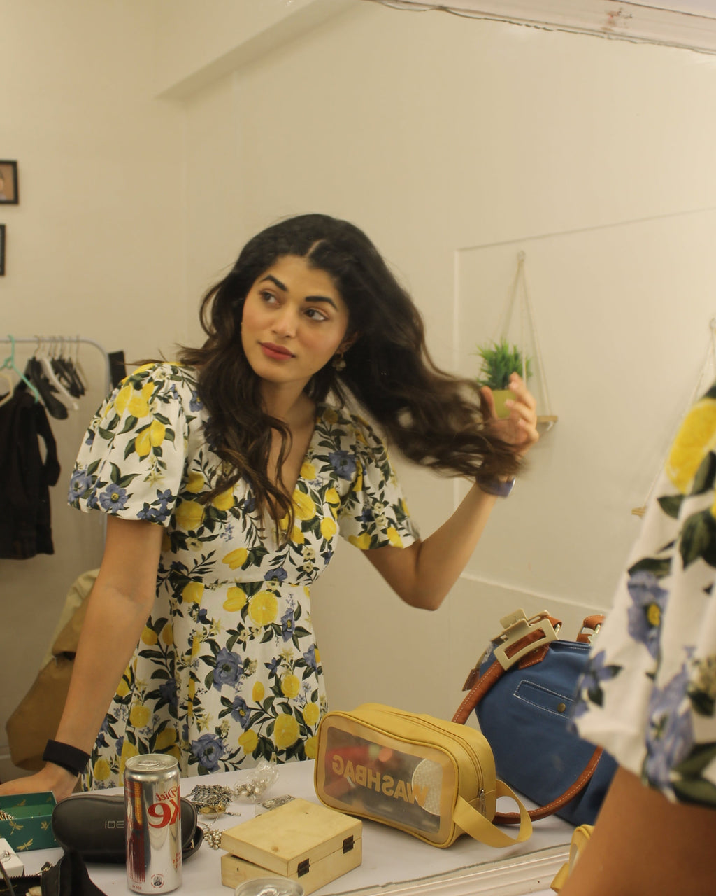 Woman in a Khamna summery citrus bloom dress standing in front of a mirror in a store.
