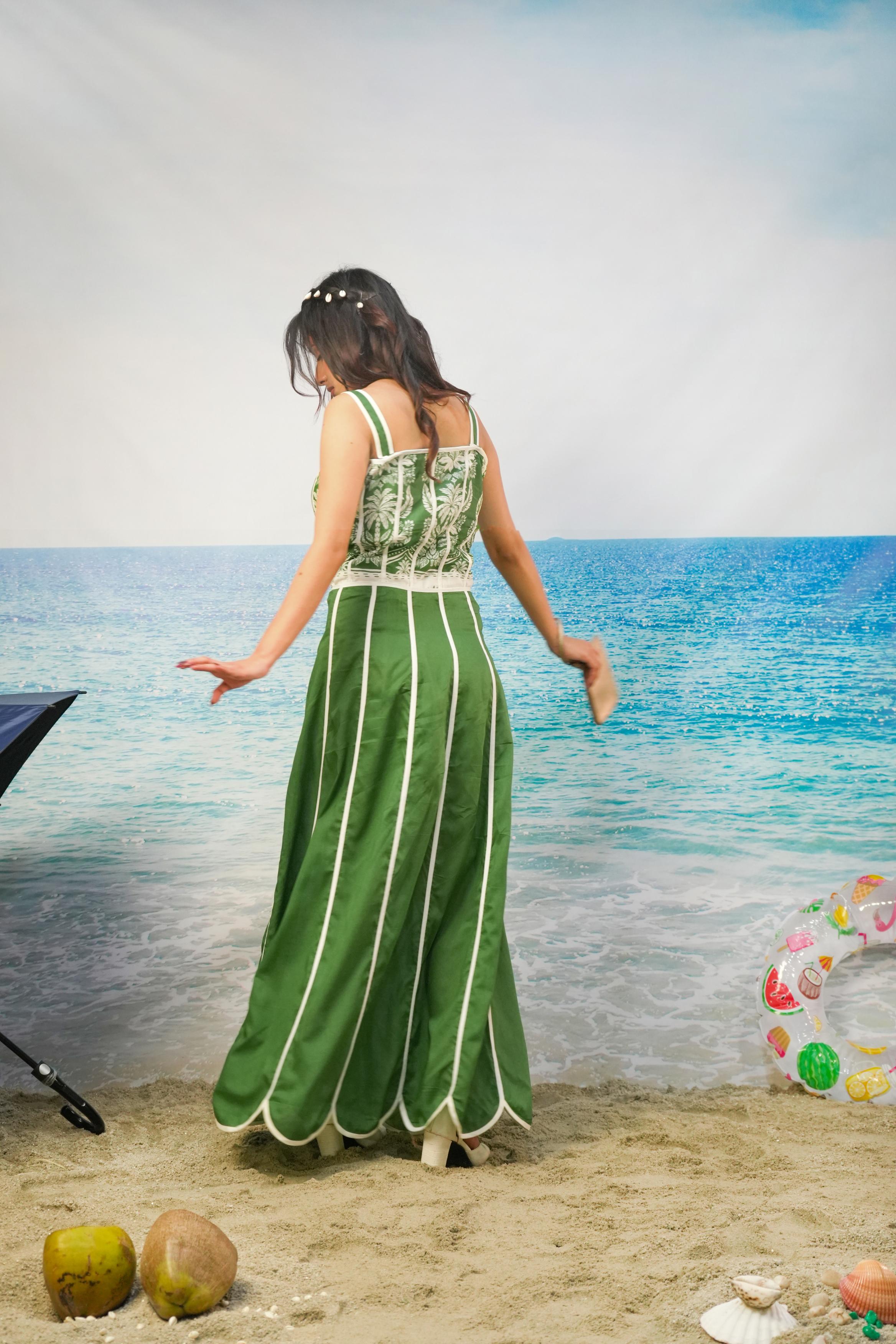 A woman stands on a sandy beach facing a blue ocean backdrop,Kavya Cotton Cambric Scalloped Co-ord Set
