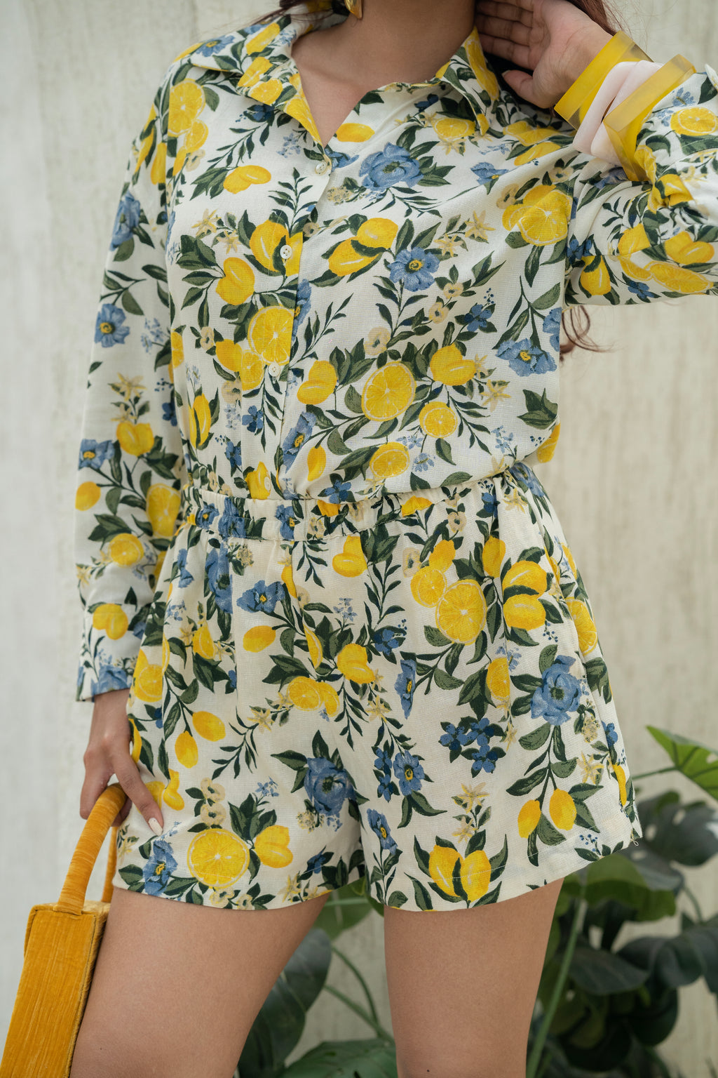 Person wearing Citrus Bloom Oversized Shirt – Printed Cotton Flax with lemon and Blue Floral pattern against a neutral background