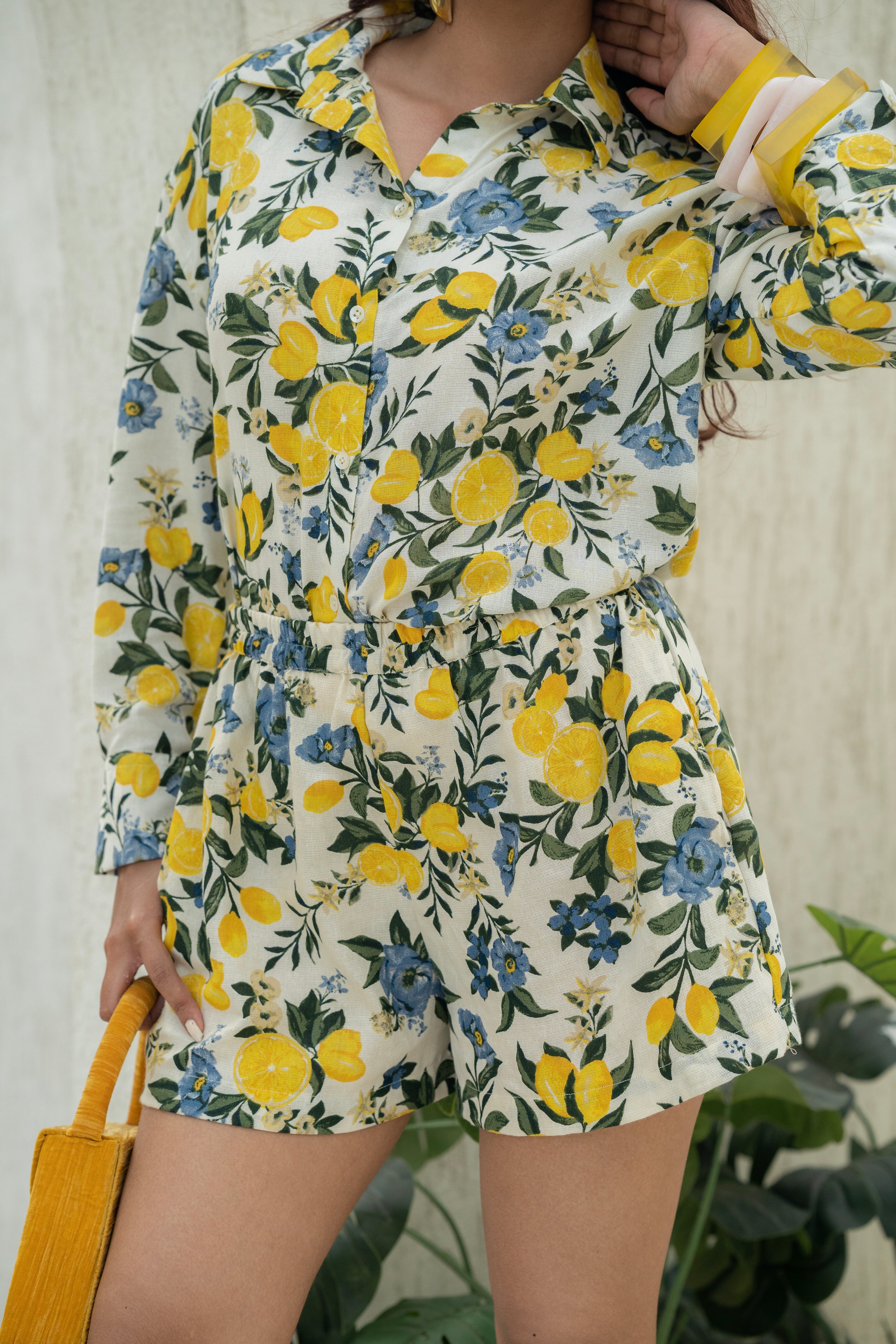 Person wearing Citrus Bloom Oversized Shirt – Printed Cotton Flax with lemon and Blue Floral pattern against a neutral background