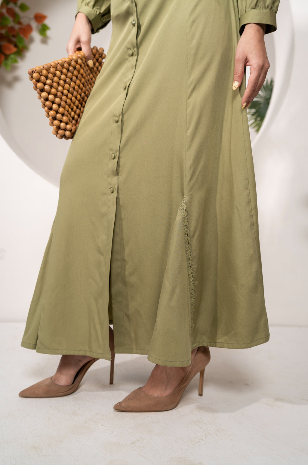 Person wearing a long Olive Reverie Co-ord Set – Lace Detail Modal Shirt & Skirt with a wooden clutch on a white background