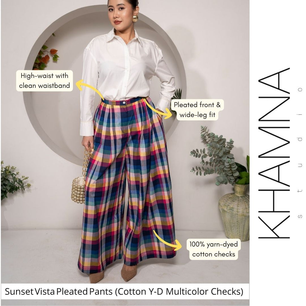 Woman wearing Sunset Vista Pleated Pants – Cotton Y/D Multicolor Checks with text highlighting features, against a neutral background.