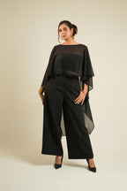 A woman modeling Vrinda Three-Piece Black Co-ord Set | Tube Top, Cape & Wide-Leg Pants standing against a plain beige studio background.