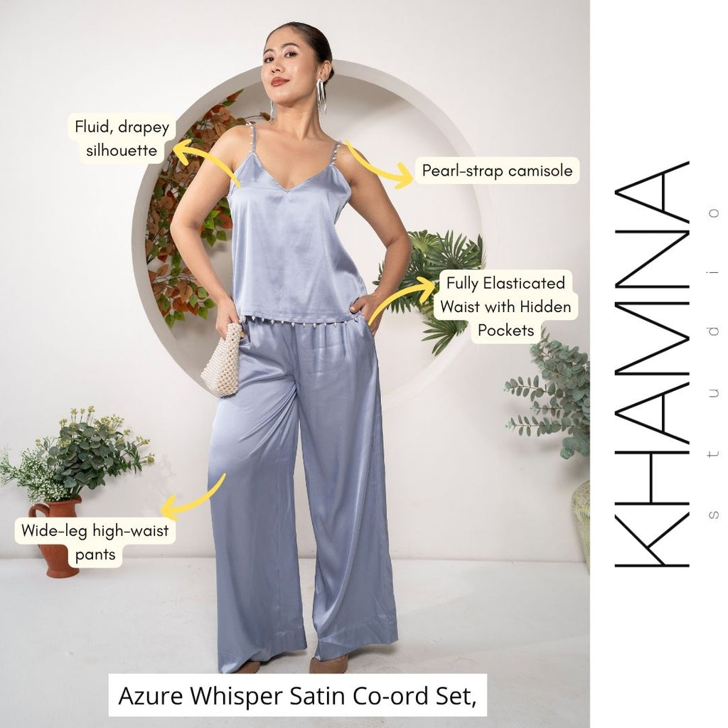 Woman wearing an azure satin co-ord set with text highlighting features, set against a white background with plants.