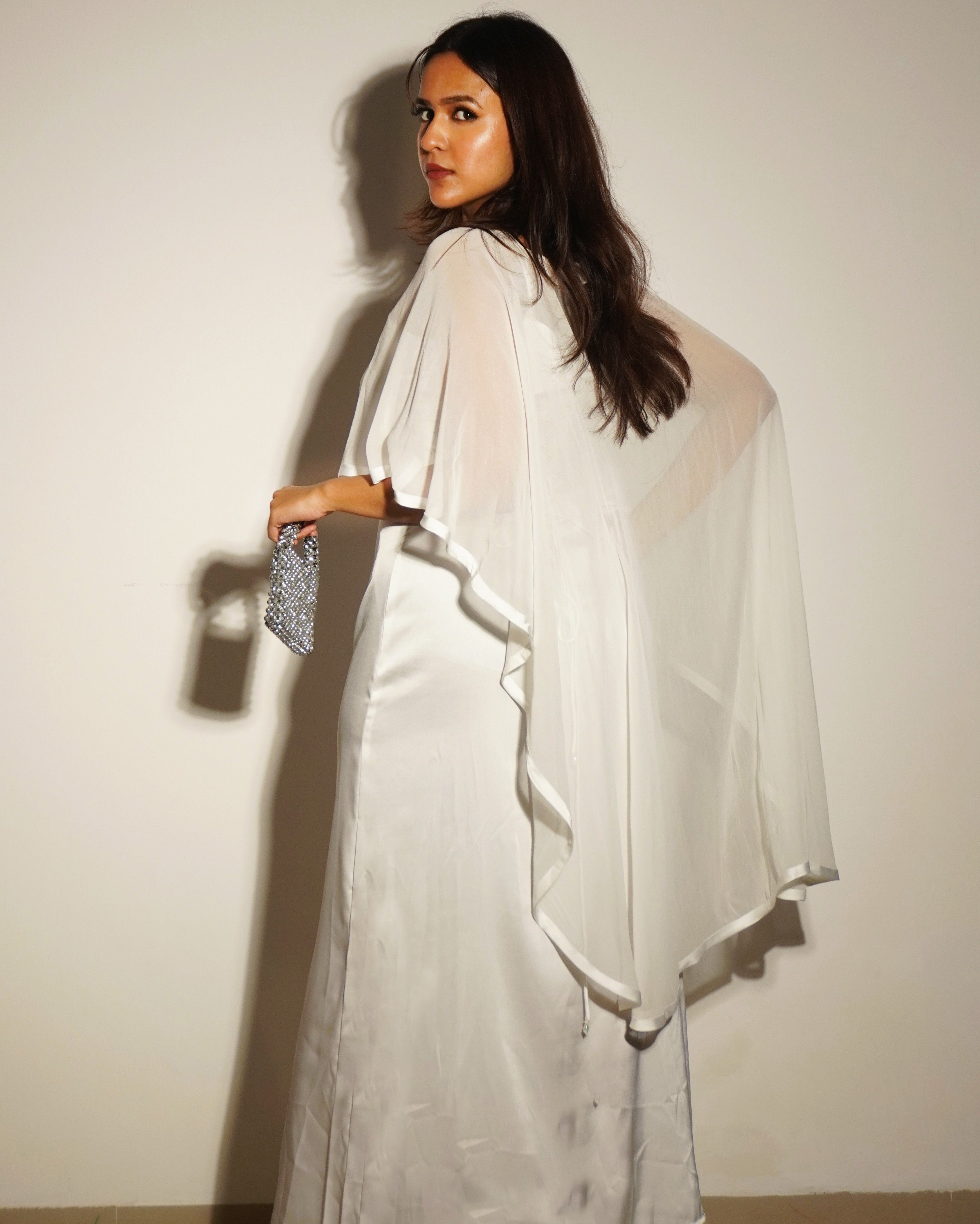 Woman wearing a white dress with a plain background