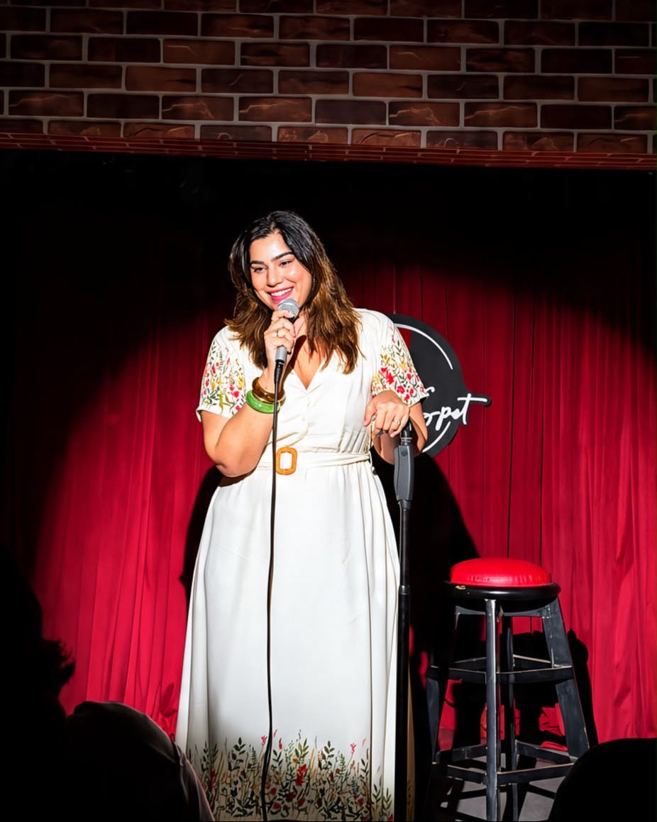 Comedian Kanisha Malhotra seen on stage wearing Khamna Zareen dress during her standup show